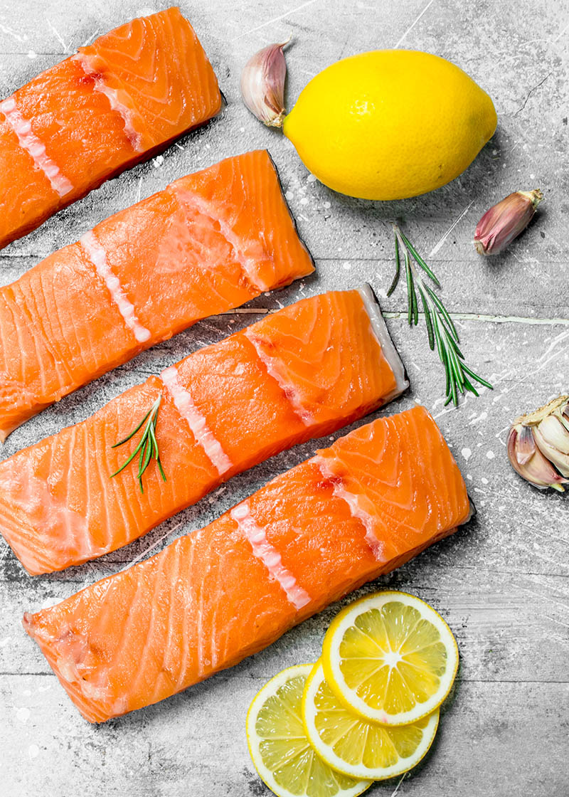 Raw salmon fish filet with lemon and rosemary.