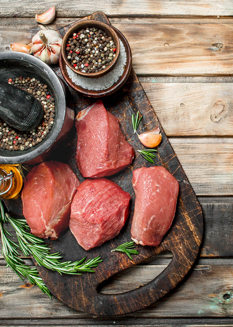 Raw meat. Pieces of fresh beef with spices and herbs .